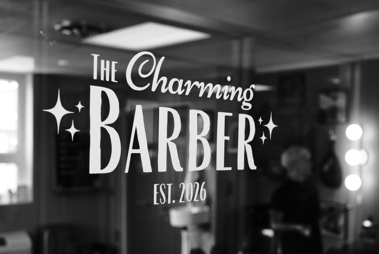 The Charming Barber logo etched on the shop window